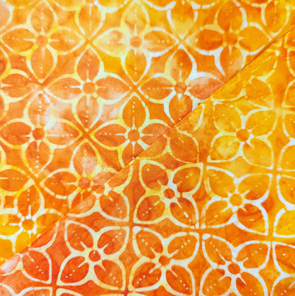 Hand block printed batik fabric from Java, Indonesia. Bright orange cotton batik with yellow and white flowers.