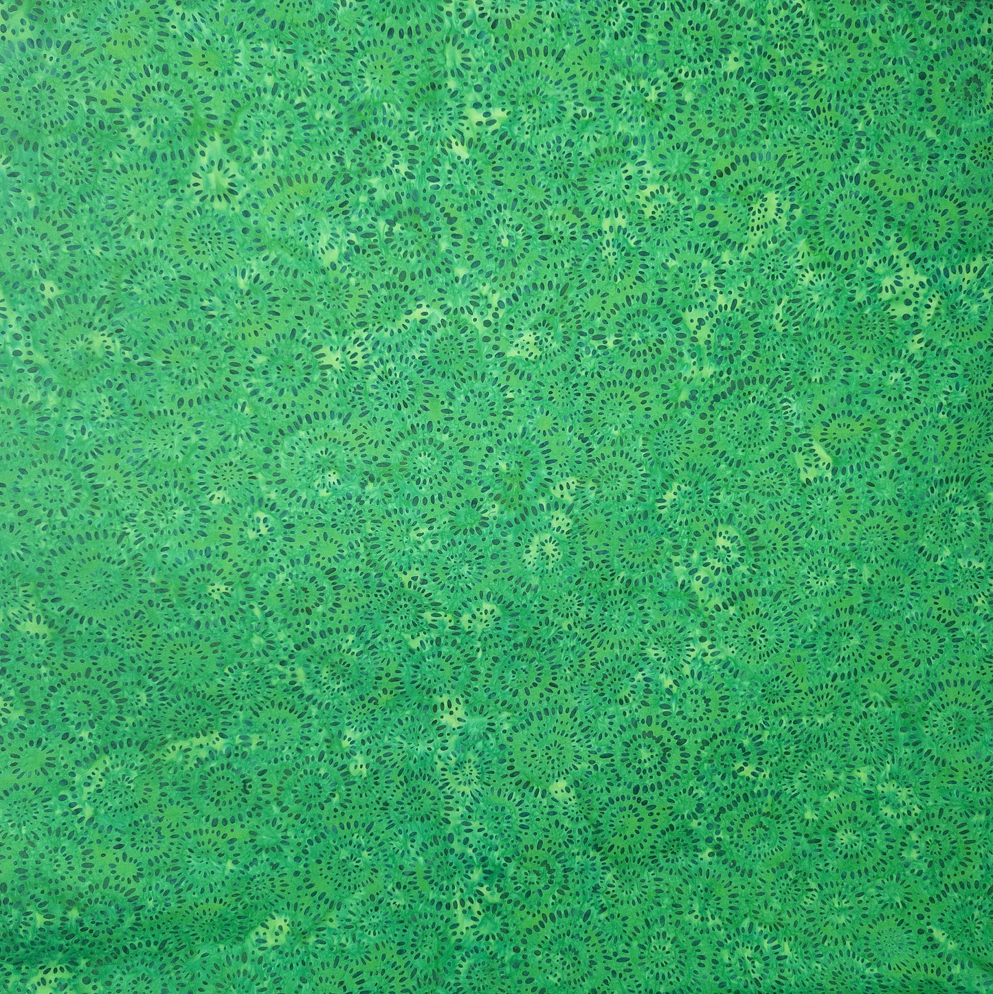 Green batik fabric from Indonesia with circle firework-inspired pattern