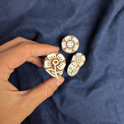 Four petalled flower stamp, shown as part of a set of floral wood blocks