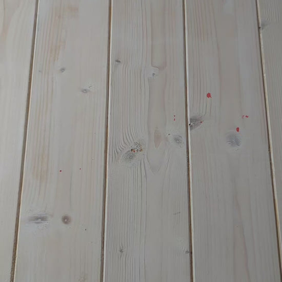 A video showing a bolt of blue ikat fabric, followed by a close up of a hand scrunching the fabric, and then a woman holding the fabric to display its full ikat pattern in red and white.