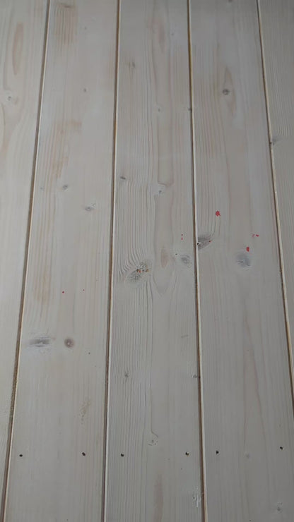 A video showing a bolt of blue ikat fabric, followed by a close up of a hand scrunching the fabric, and then a woman holding the fabric to display its full ikat pattern in red and white.